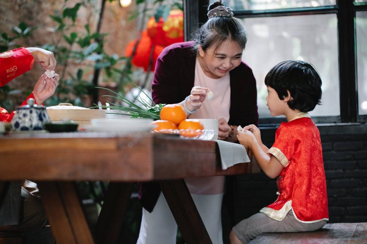 a mother and a child folding dumplings